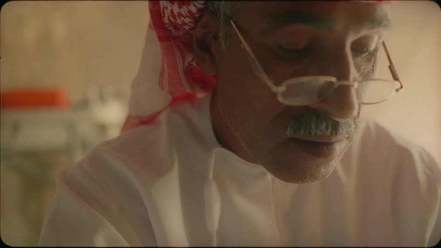 A middle eastern man reads from a book