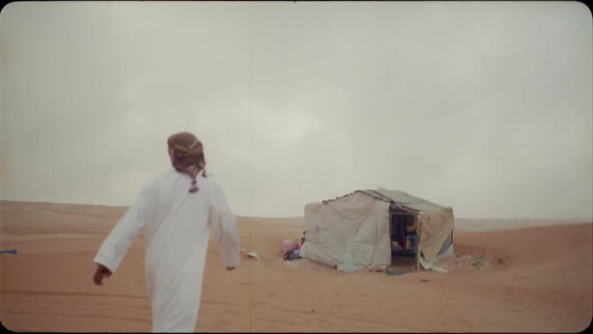 Man walks towards a tent in the desert