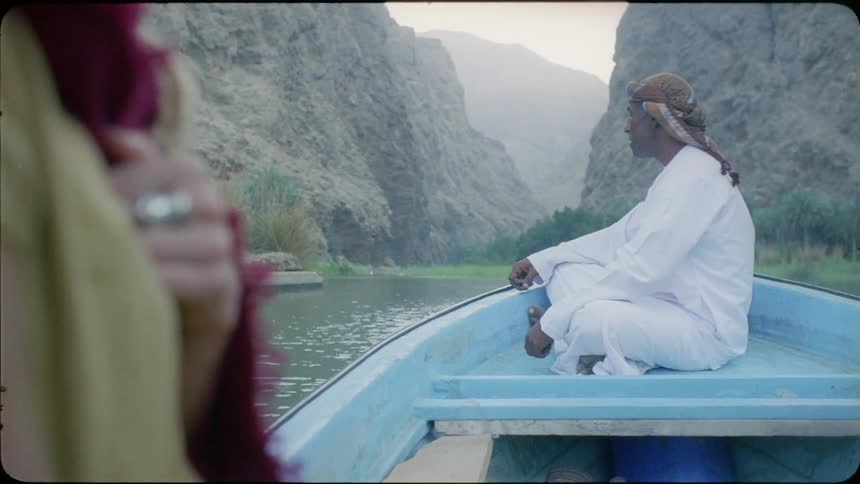 A man sits on the boat as it moves slowly