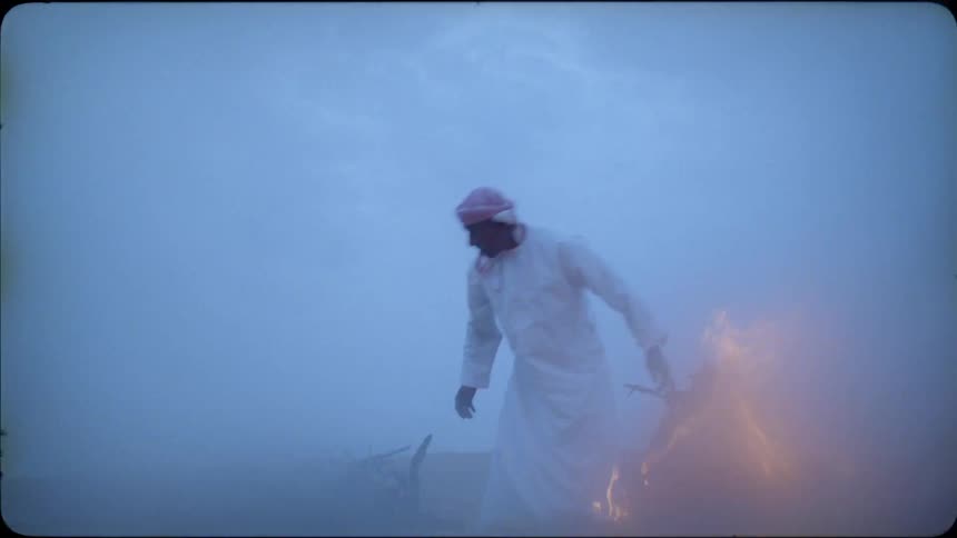 A man breaks branches to throw in the fire