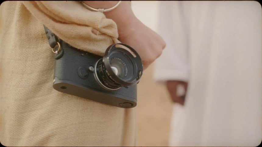 The woman has a camera hanging from a strap