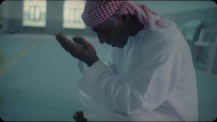A middle eastern man prays in a mosque