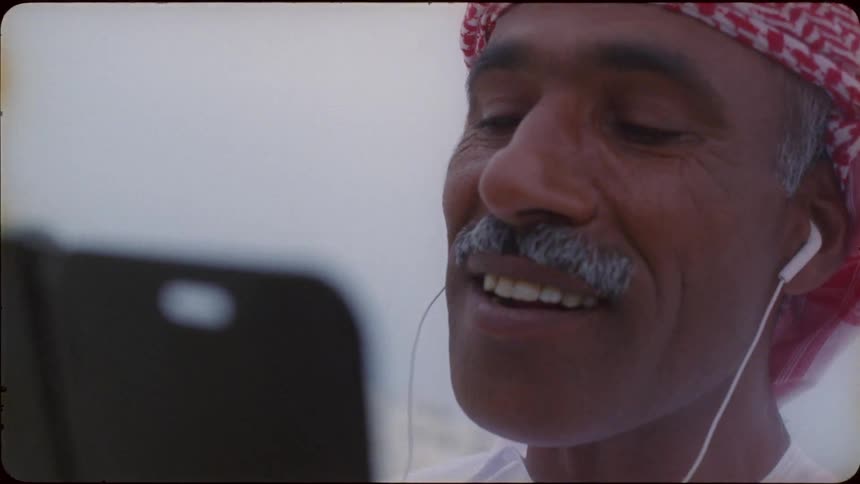 A man wearing earbuds is smiling