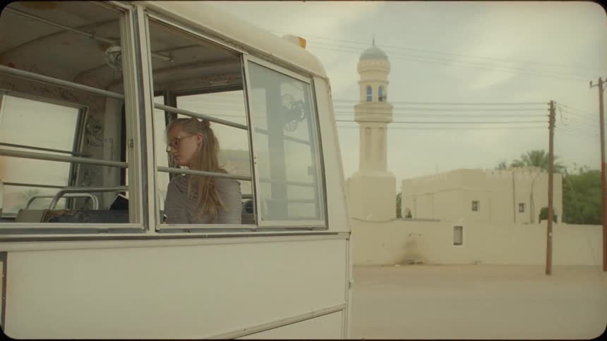 A woman sits in the back of a van