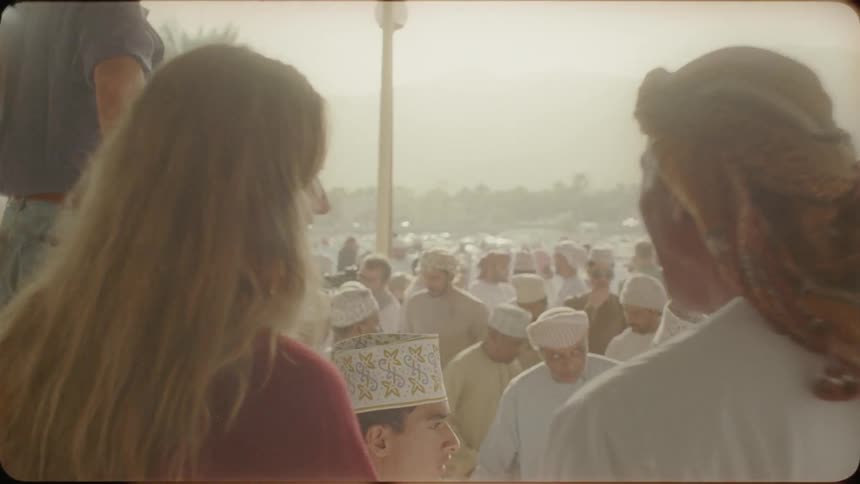 Woman smiles and talks to a man in a crowd of people