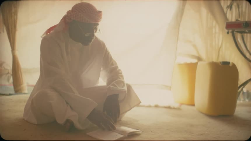 A man sits in his tent reading