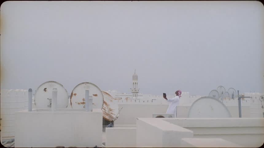 A middle eastern man uses a tablet on the rooftop