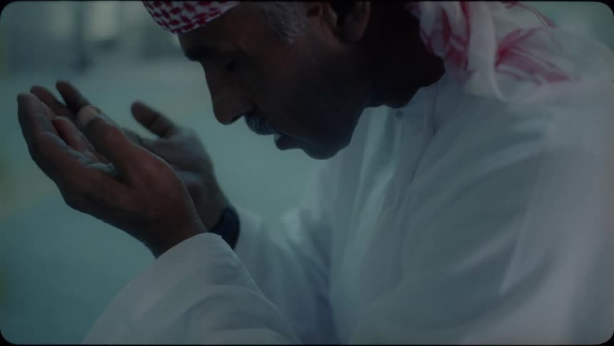 A middle eastern man prays in a mosque