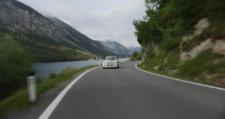 A car speeds on a mountain road