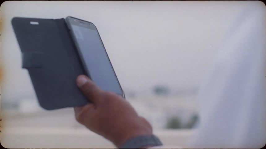 Person standing outside looking at their phone