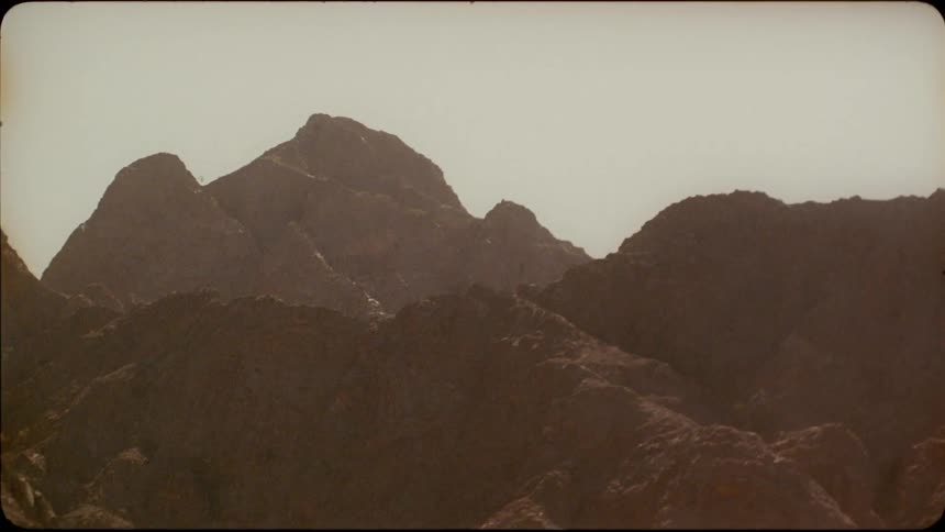 Sun shines on tall rocky mountains