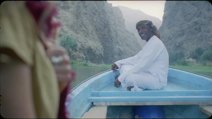 Man smiles while riding on a boat