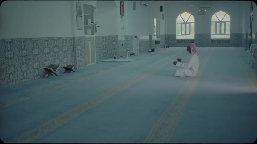 A middle eastern man prays in a mosque