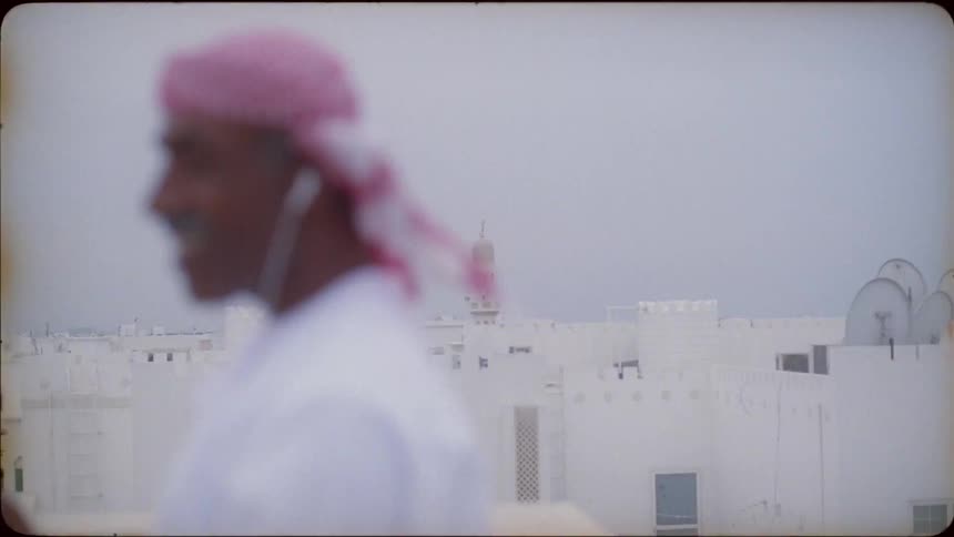 A man laughs and talks on a phone on the roof