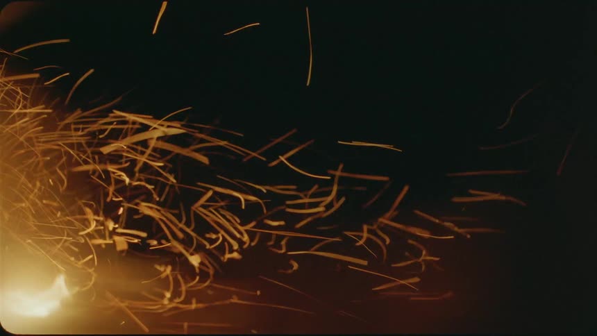 Embers are blown from a fire by the wind