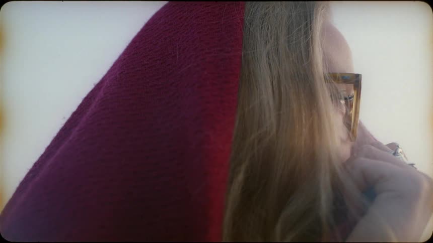 A blond haired woman has a red scarf over her head