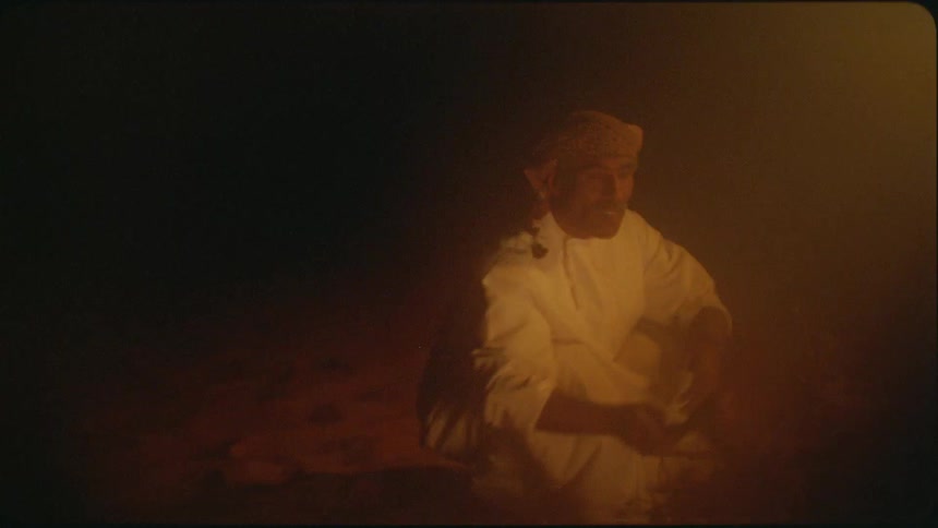 A man throws kindling onto a fire