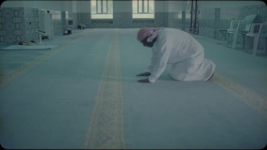 Man kneels on the floor and kisses it then stands up