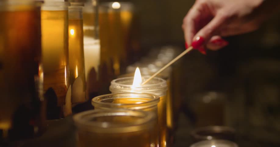 A woman lights a candle