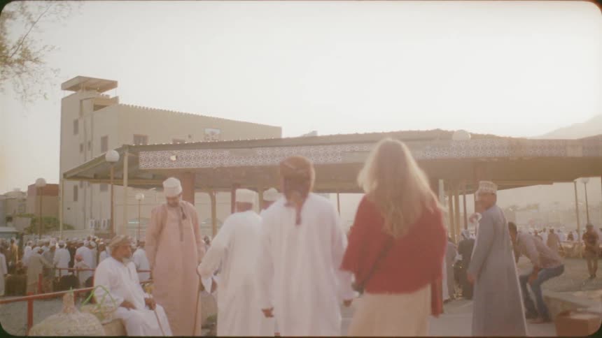 A blond haired woman and men walk outside