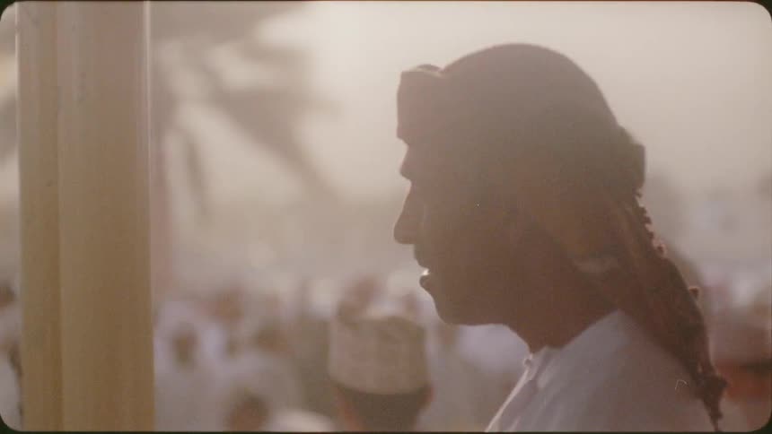 Man watches the crowd under a cloudy sky