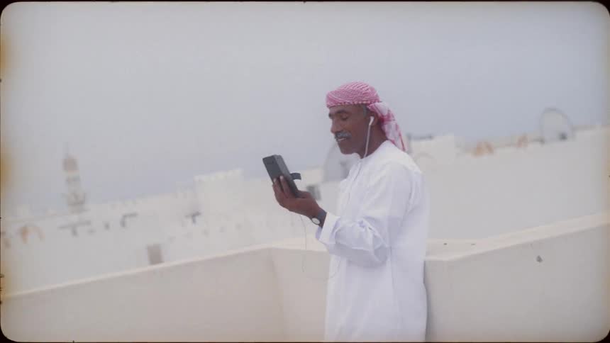 A man uses a tablet on the rooftop