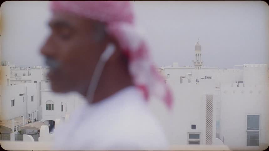 A middle eastern man stands on a rooftop