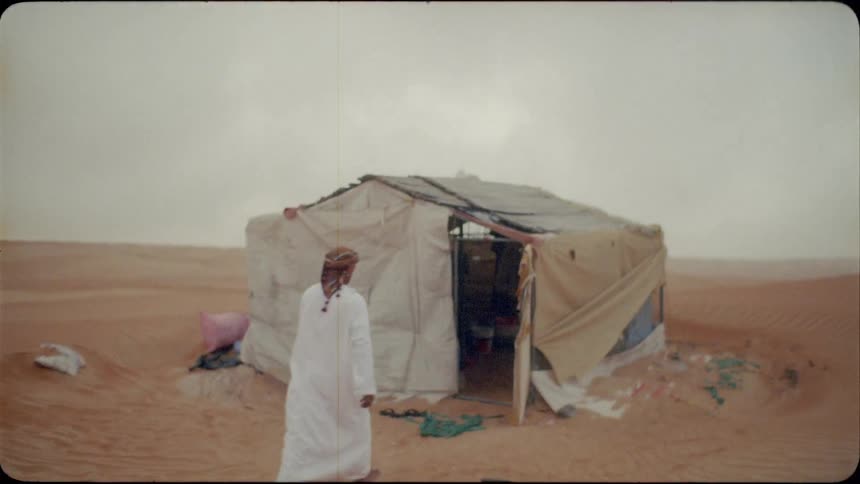 A man enters a tent set up in the desert