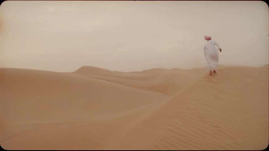 Man wearing a turban walks through the desert