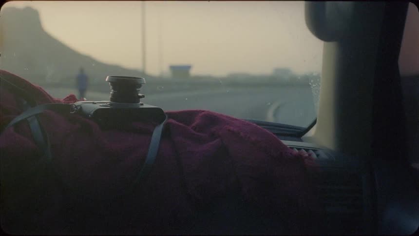 Car is driven on a road at sunset