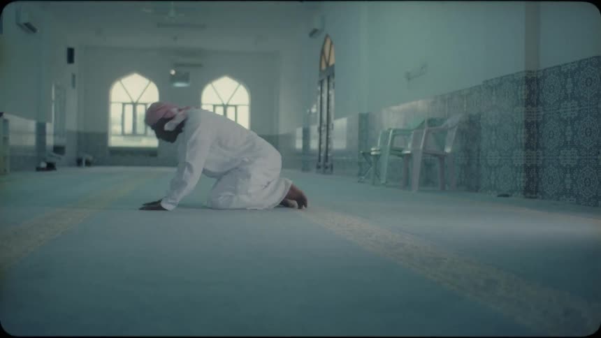 A middle eastern man prays in a mosque