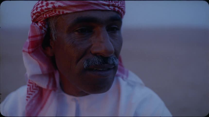 A middle eastern man talks in the desert