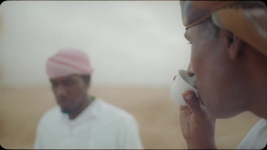 Arab men talk and drink tea outside