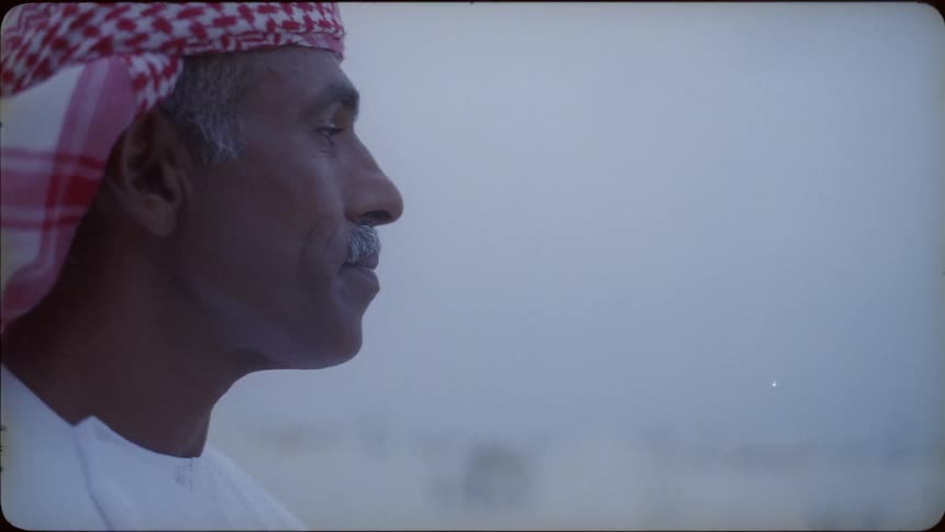 The man is looking around in the desert