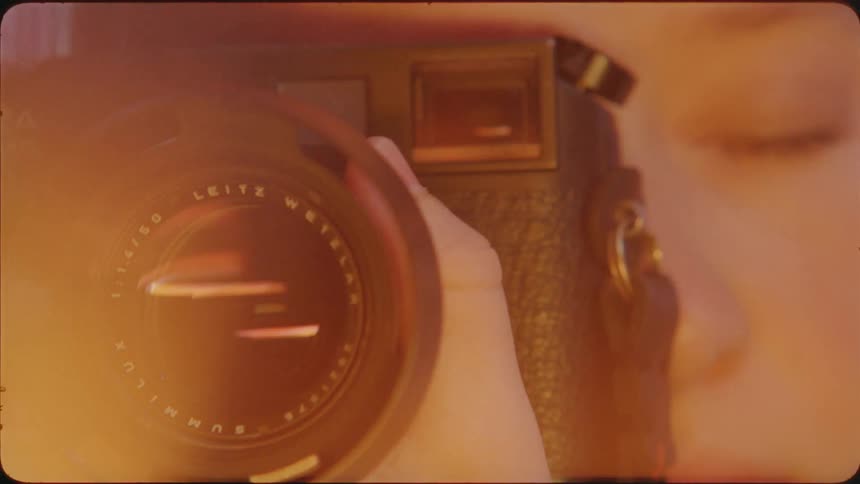 A photographer focuses a camera lens