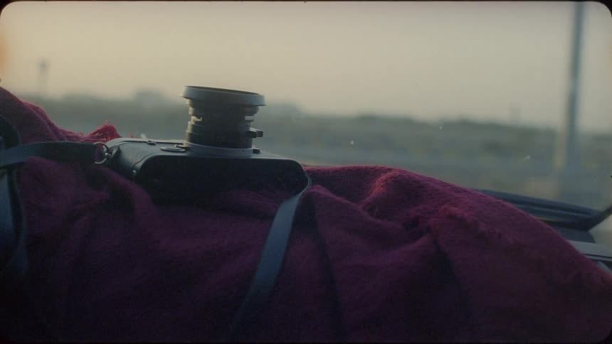 Camera sits on a red blanket on the dashboard of a car