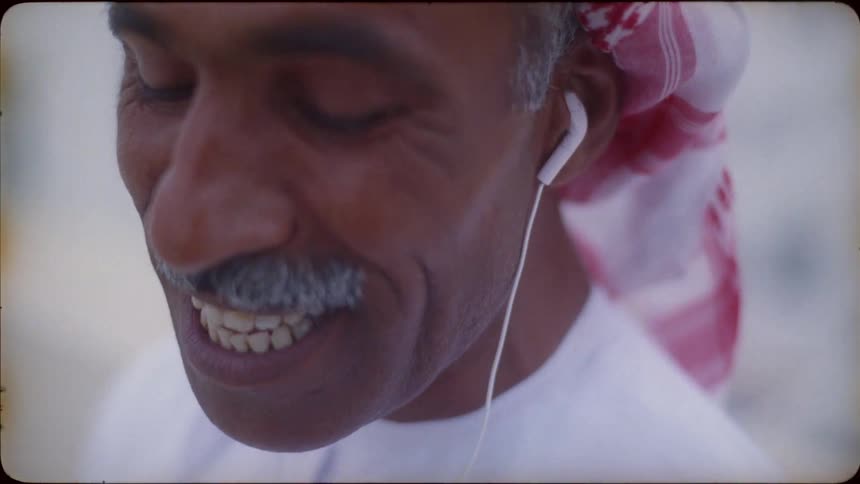 A man is wearing earbuds while he talks