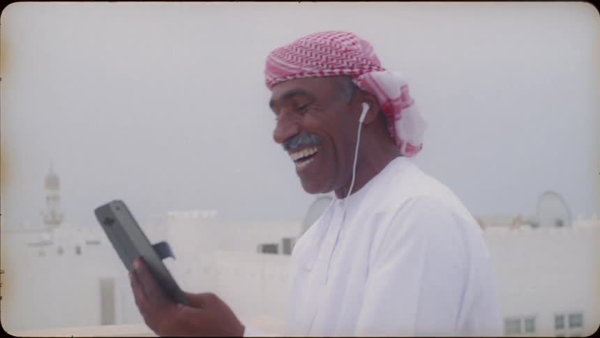 A man laughs as he talks to someone on his phone