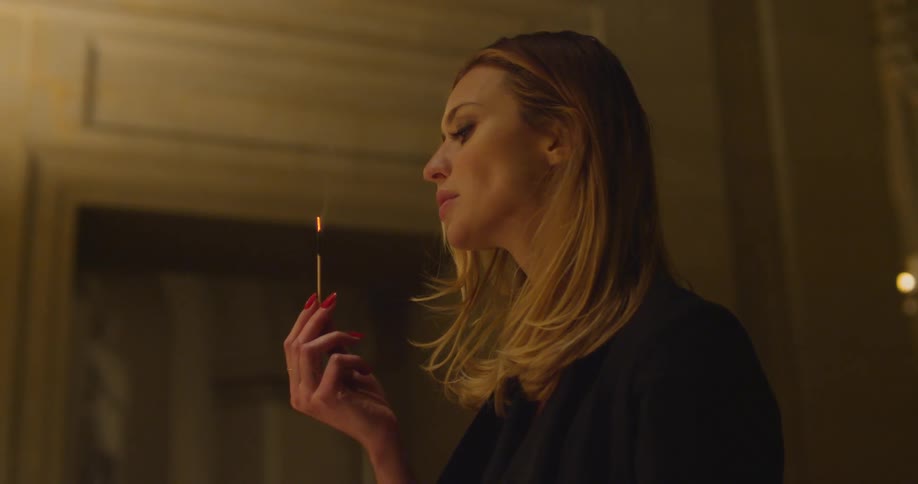 Woman blowing out a lit match