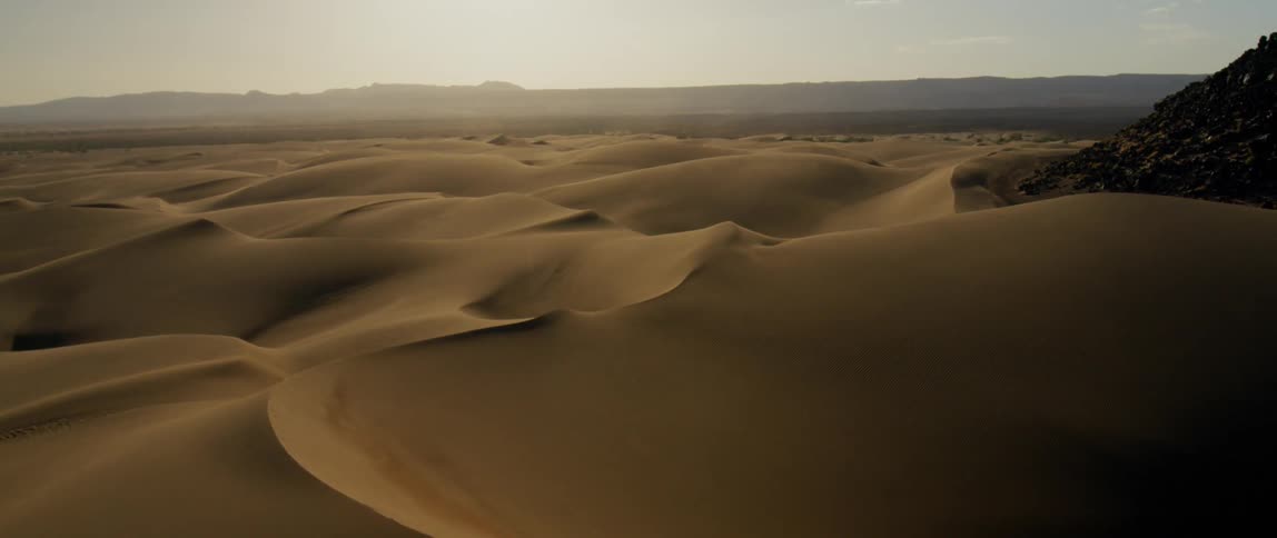 The desert sand sits under a sunny sky