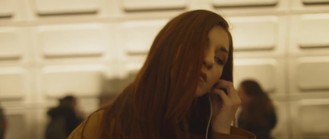 Woman puts earbud into her ear