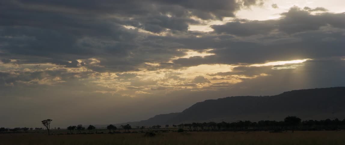 Sun sets over hills and flat plains