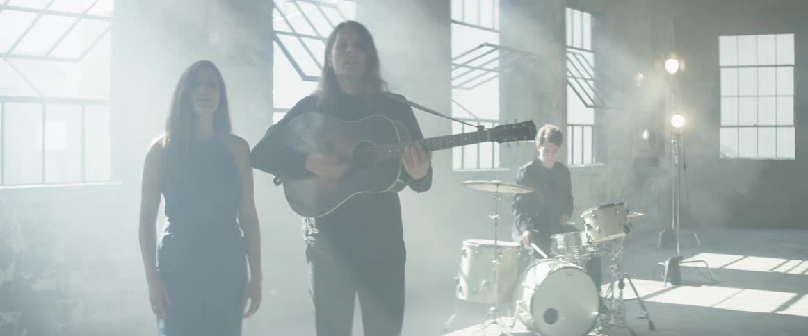 A band performs in a bright and empty room
