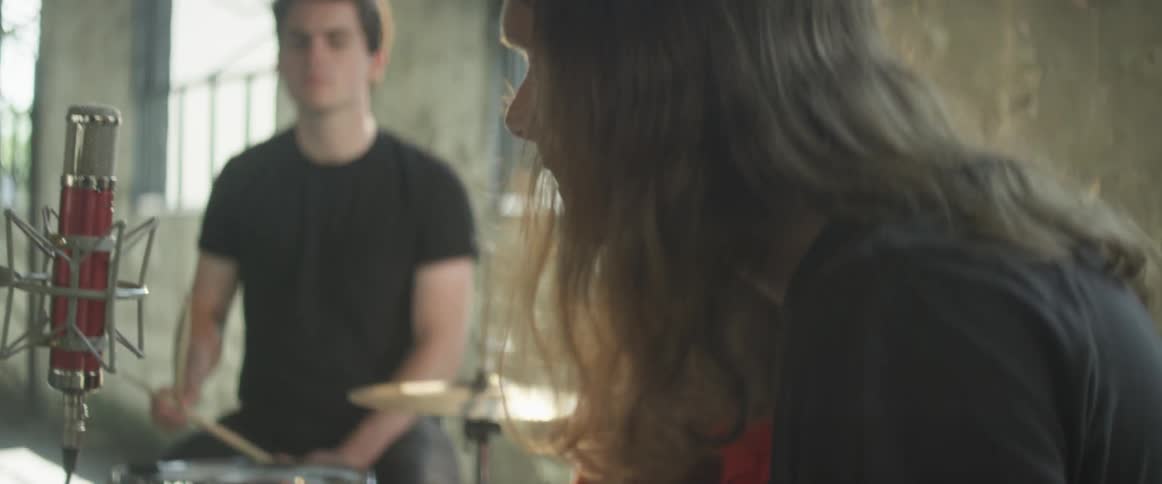 A band performs in a bright and empty room