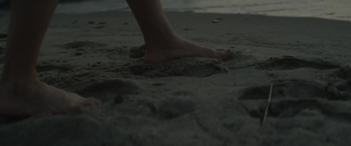 People walk barefoot on the beach