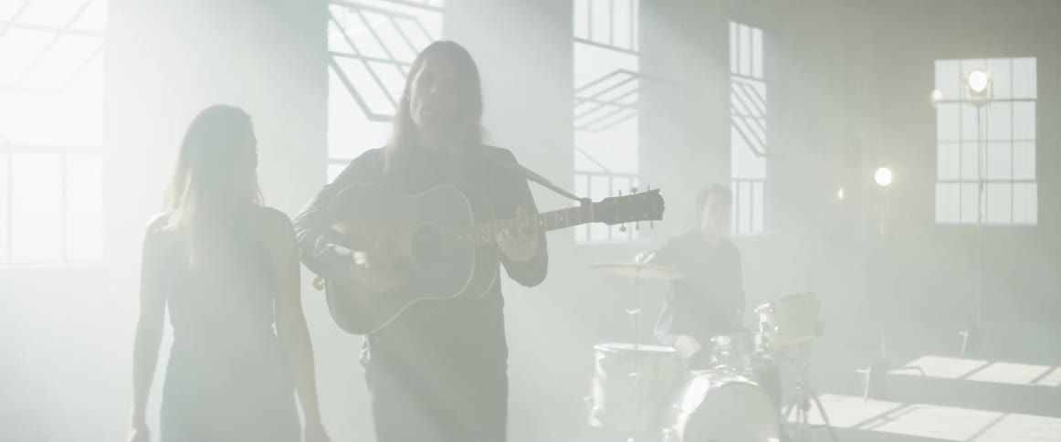 A band performs in a bright and empty room