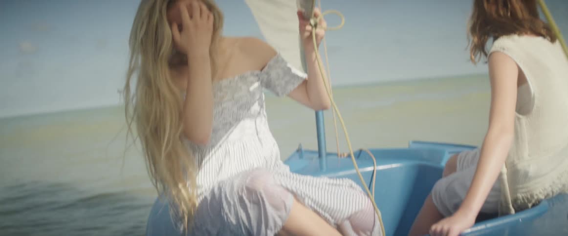 Woman riding on a boat smiles and touches her hair