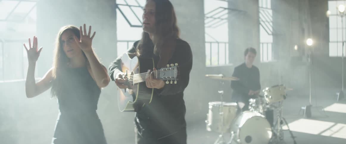 A band performs in a bright and empty room