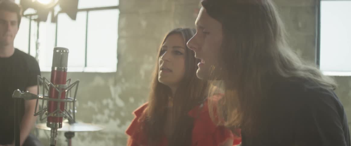 Man and woman sing in a studio on a sunny day