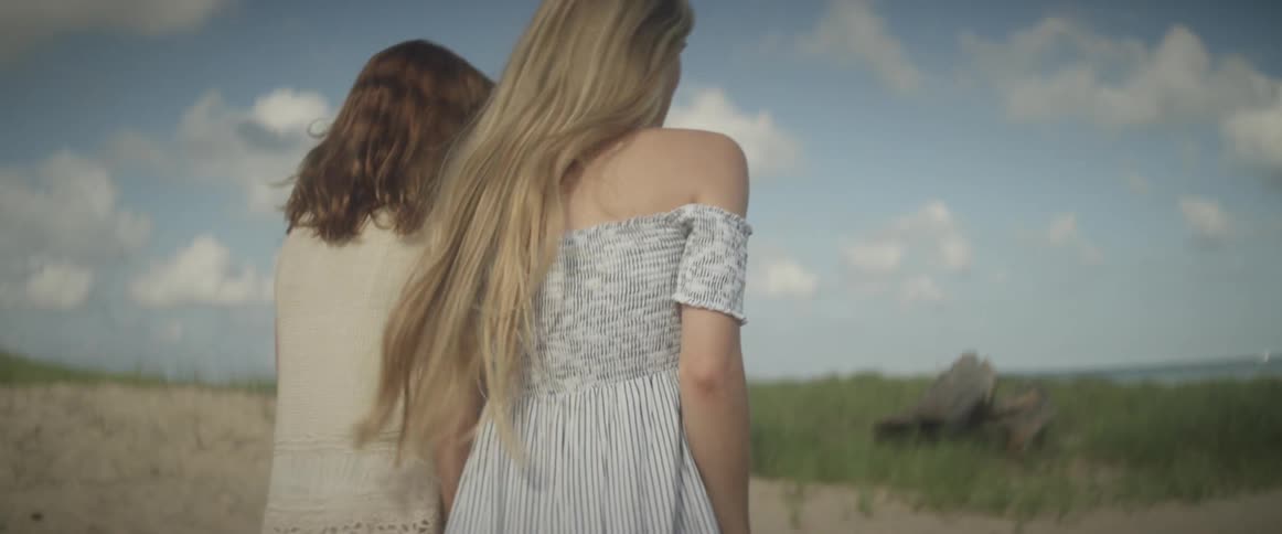 Two women walk on a beach